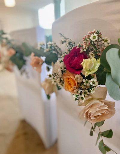 Mila Bloom - Deko & Blumen mit Woweffekt - Hochzeit auf Schloß Landau - Ausdrucksstarkes Farbkonzeot mit pink und apricot sowie Eukalyptus - Kirchendekoration - Blumen für die Brautpaarstühle